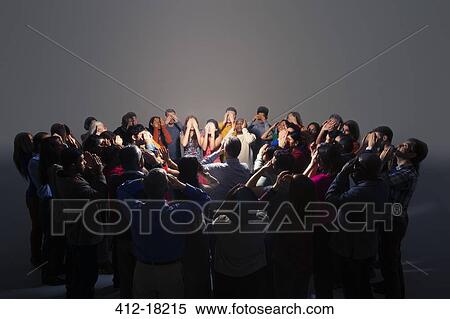 Business people covering eyes around bright light View Large Photo Image Stock Photography - Business people covering eyes around bright light. Fotosearch