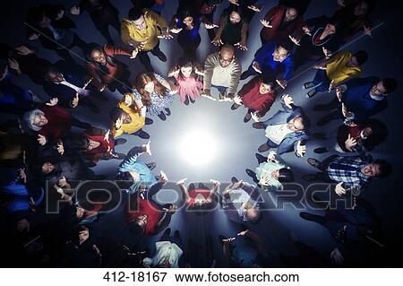 Business people forming circle around bright light View Large Photo Image Stock Photo - Business people forming circle around bright light. Fotosearch