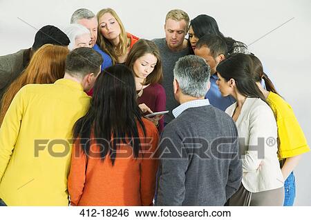 Business people huddled around businesswoman with laptop View Large Photo Image Stock Photograph - Business people huddled around businesswoman with laptop. Fotosearch