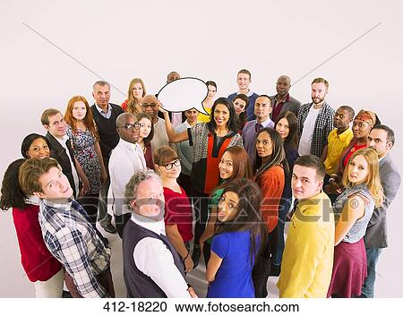 Stock Image - Business people surrounding businesswoman with speech bubble. Fotosearch