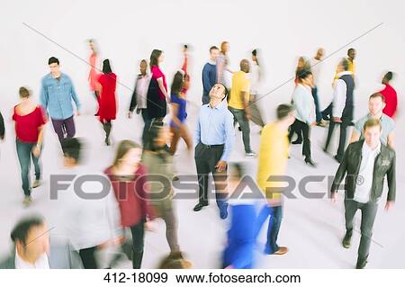 Stock Photo - Businessman standing among bustling crowd. Fotosearch