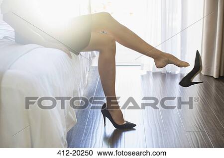 Businesswoman kicking off her shoes in hotel room View Large Photo Image Stock Image - Businesswoman kicking off her shoes in hotel room. Fotosearch