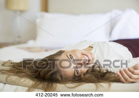 Businesswoman laying on bed in hotel room View Large Photo Image Stock Photography - Businesswoman laying on bed in hotel room. Fotosearch