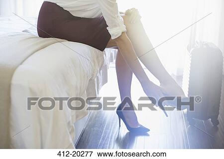 Businesswoman taking shoes off in hotel room View Large Photo Image Stock Photo - Businesswoman taking shoes off in hotel room. Fotosearch