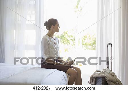 Businesswoman using digital tablet in hotel room View Large Photo Image Stock Image - Businesswoman using digital tablet in hotel room. Fotosearch