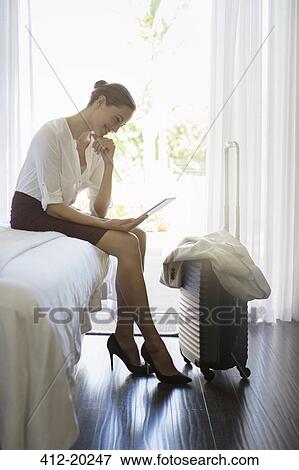 Businesswoman using digital tablet in hotel room View Large Photo Image Stock Photo - Businesswoman using digital tablet in hotel room. Fotosearch