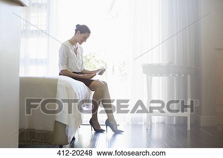 Stock Photo - Businesswoman using digital tablet in hotel room. Fotosearch
