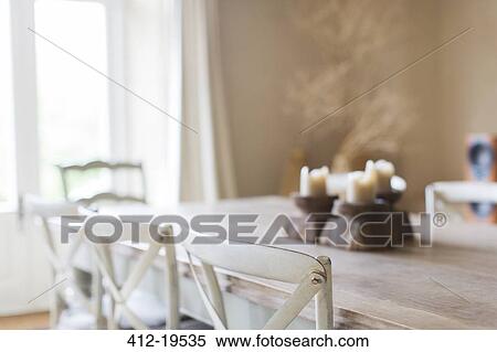 Stock Photography - Candles on dining table of rustic house. Fotosearch