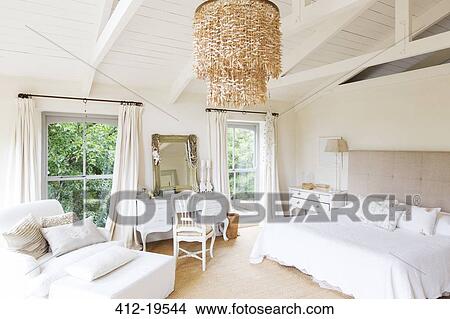 Picture - Chandelier and armchair in rustic bedroom. Fotosearch