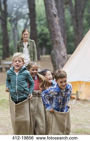 Children having sack race at campsite View Large Photo Image Stock Photograph - Children having sack race at campsite. Fotosearch