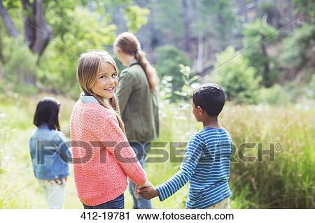 Children holding hands in field View Large Photo Image Stock Image - Children holding hands in field. Fotosearch