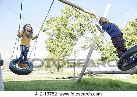 Children playing on tire swings View Large Photo Image Stock Image - Children playing on tire swings. Fotosearch