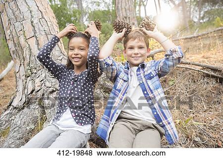 Children playing with pine cones in forest View Large Photo Image Stock Photo - Children playing with pine cones in forest. Fotosearch