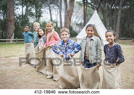 Children smiling at start of sack race View Large Photo Image Stock Photograph - Children smiling at start of sack race. Fotosearch