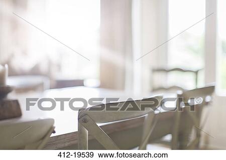 Stock Photo - Close up of chairs at dining room table. Fotosearch