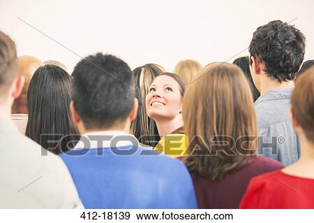 Stock Photo - Confident woman looking up in crowd. Fotosearch