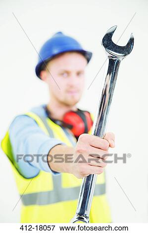 Construction worker holding large wrench View Large Photo Image Stock Photo - Construction worker holding large wrench. Fotosearch