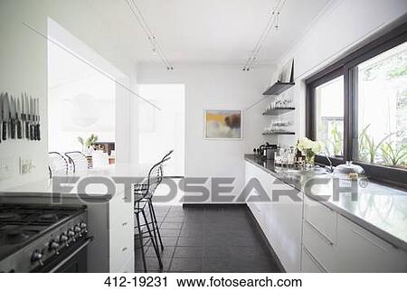 Stock Image - Counters and breakfast bar in modern kitchen. Fotosearch