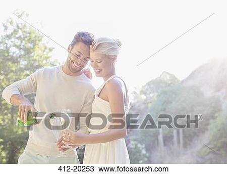 Couple drinking champagne outdoors View Large Photo Image Stock Image - Couple drinking champagne outdoors. Fotosearch