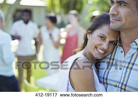 Stock Photo - Couple hugging at dinner party. Fotosearch