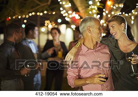 Couple hugging at party View Large Photo Image Picture - Couple hugging at party. Fotosearch