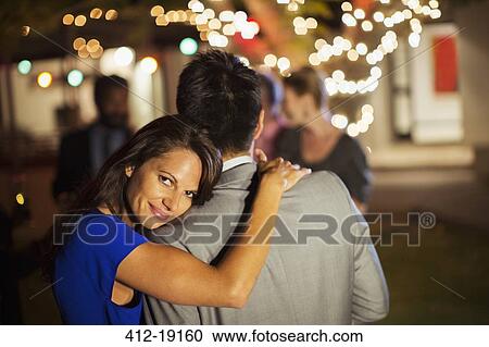 Couple hugging at party View Large Photo Image Stock Image - Couple hugging at party. Fotosearch