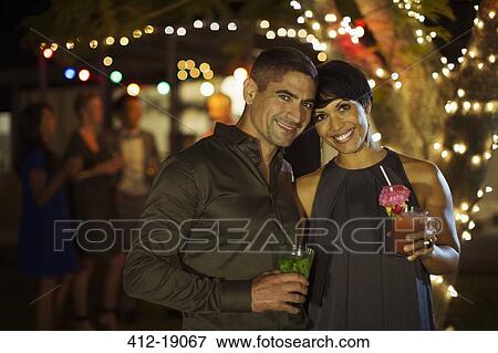 Stock Photo - Couple hugging at party. Fotosearch