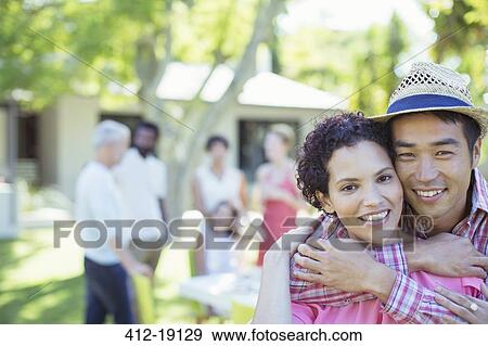 Stock Photo - Couple hugging at party. Fotosearch