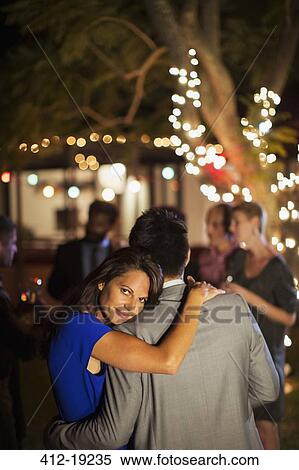 Stock Photography - Couple hugging at party. Fotosearch