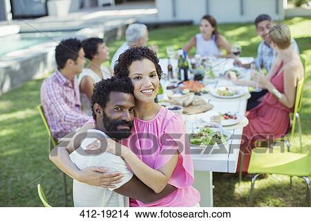 Couple hugging at table outdoors View Large Photo Image Picture - Couple hugging at table outdoors. Fotosearch