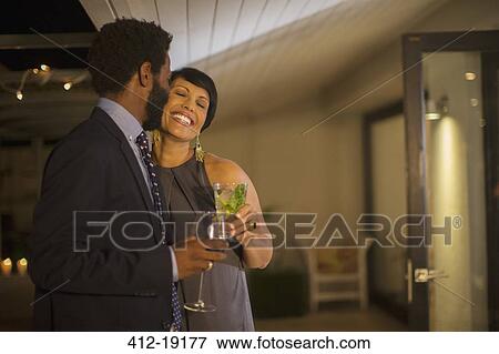 Stock Photo - Couple kissing at party. Fotosearch