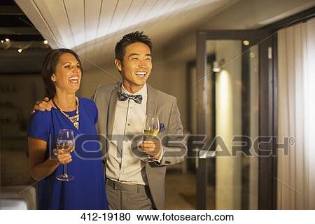 Couple laughing together at party View Large Photo Image Stock Image - Couple laughing together at party. Fotosearch