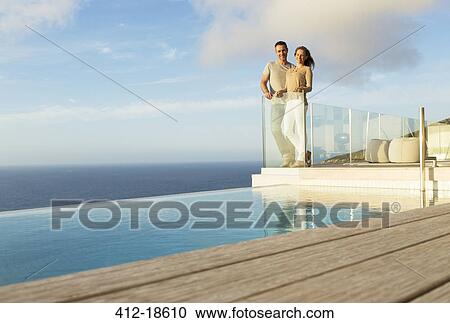 Couple on modern balcony overlooking ocean View Large Photo Image Stock Image - Couple on modern balcony overlooking ocean. Fotosearch