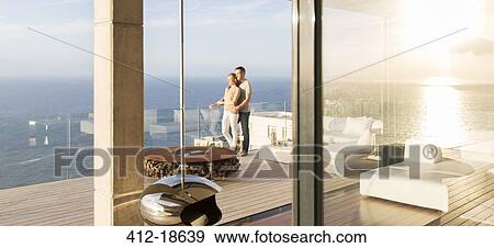Couple on modern balcony overlooking ocean View Large Photo Image Stock Photo - Couple on modern balcony overlooking ocean. Fotosearch
