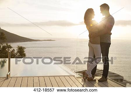 Couple on wooden deck overlooking ocean View Large Photo Image Stock Photo - Couple on wooden deck overlooking ocean. Fotosearch