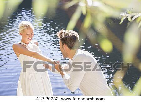 Stock Image - Couple playing by pool. Fotosearch