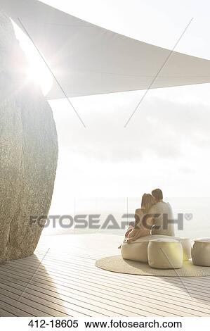 Couple relaxing together on modern balcony View Large Photo Image Stock Photography - Couple relaxing together on modern balcony. Fotosearch