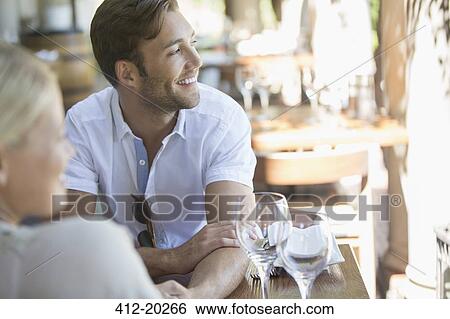 Couple sitting together in restaurant View Large Photo Image Stock Photograph - Couple sitting together in restaurant. Fotosearch