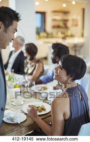 Stock Photography - Couple talking at dinner party. Fotosearch