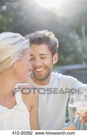 Stock Image - Couple toasting each other with champagne together outdoors. Fotosearch