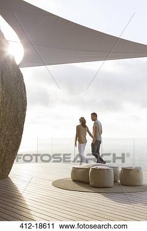 Couple walking on modern balcony View Large Photo Image Stock Image - Couple walking on modern balcony. Fotosearch
