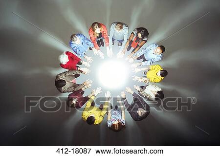 Crowd forming circle around bright light View Large Photo Image Stock Photo - Crowd forming circle around bright light. Fotosearch