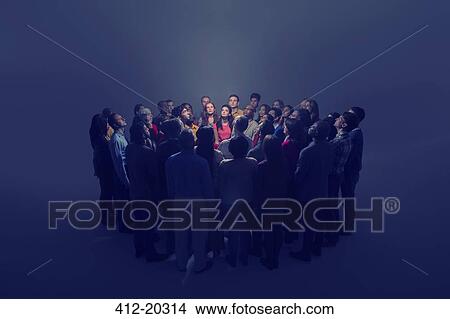 Picture - Diverse crowd around bright light. Fotosearch