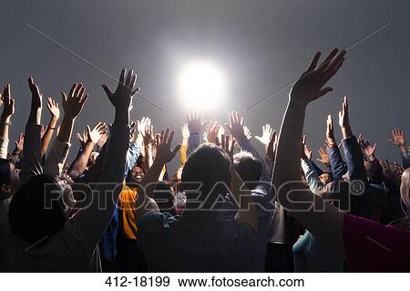 Diverse crowd cheering around bright light View Large Photo Image Stock Photo - Diverse crowd cheering around bright light. Fotosearch