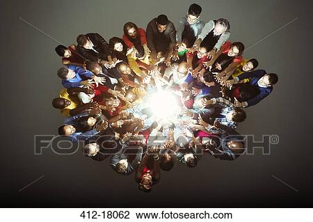 Stock Image - Diverse workers around bright light. Fotosearch