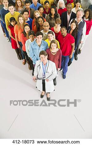 Doctor standing in front of diverse crowd View Large Photo Image Stock Image - Doctor standing in front of diverse crowd. Fotosearch
