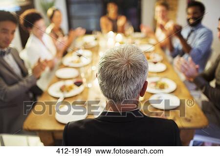 Stock Photo - Friends applauding at dinner party. Fotosearch