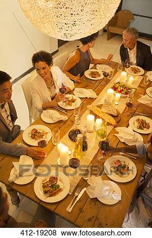 Friends eating together at dinner party View Large Photo Image Stock Photo - Friends eating together at dinner party. Fotosearch