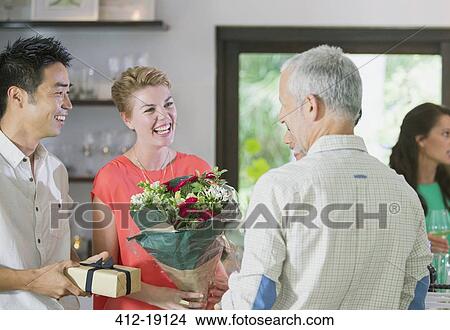 Picture - Friends exchanging gifts at party. Fotosearch