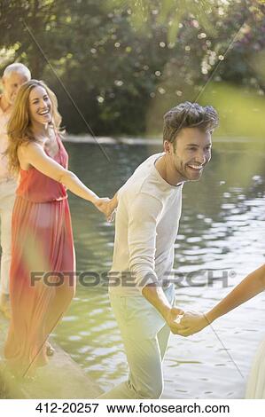 Friends holding hands by pool View Large Photo Image Stock Photo - Friends holding hands by pool. Fotosearch